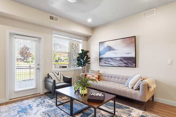 Living room with a leather couch at The Flats at Riverwoods, Provo, UT, 84604