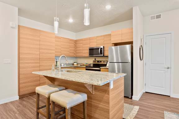 Kitchen with a refrigerator at The Flats at Riverwoods, Provo, UT