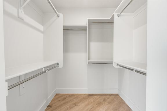 A white kitchen with a wooden floor and white walls. at The Vue At Desert Color, St. George, 84790