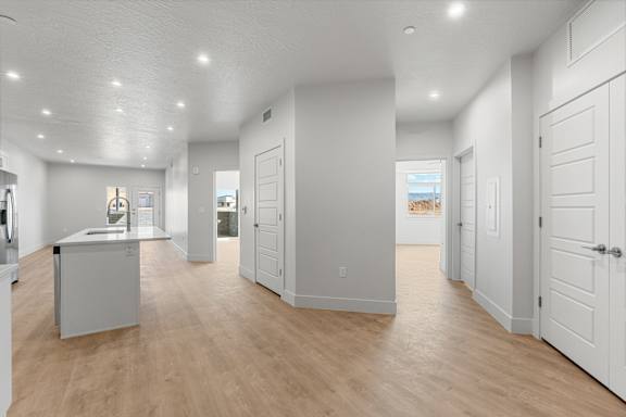 A spacious kitchen with white cabinets and a wooden floor. at The Vue At Desert Color, St. George, 84790