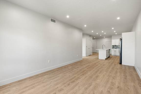 A large empty room with wooden flooring and white walls. at The Vue At Desert Color, St. George, UT, 84790