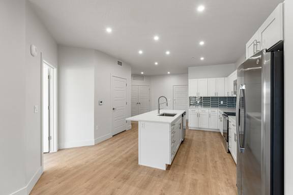 A modern kitchen with white cabinets and stainless steel appliances. at The Vue At Desert Color, Utah, 84790