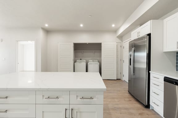 A modern kitchen with white cabinets and a stainless steel refrigerator. at The Vue At Desert Color, Utah, 84790