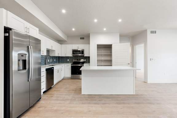 A modern kitchen with stainless steel appliances and white cabinetry. at The Vue At Desert Color, St. George, 84790