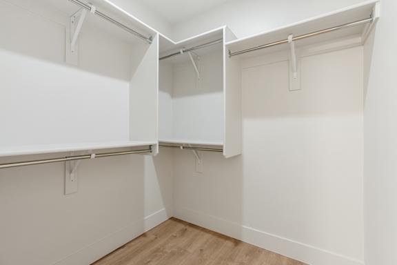 A white closet with two open doors and a wooden floor. at The Vue At Desert Color, St. George, UT, 84790