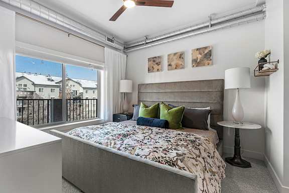 A bedroom with a large bed and a ceiling fan.