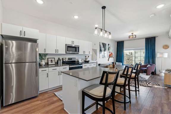 Modern kitchen island with bar seating and open floor plan at The Revival Apartments, Utah, 84101