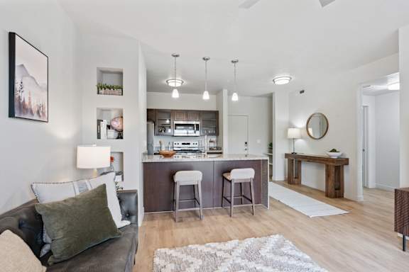 A modern living room with a couch, bar stools, and a fireplace. at Wilmington Flats Apartments, Salt Lake City, 84106