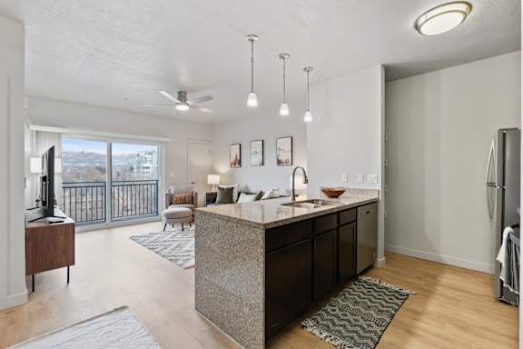A modern kitchen with a large island and a view of the city. at Wilmington Flats Apartments, Salt Lake City