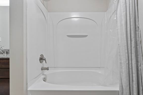 A white bathroom with a tub and a shower. at Wilmington Flats Apartments, Apartments, Salt Lake City, UT