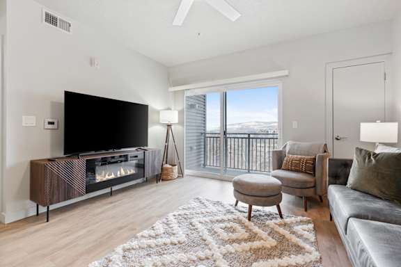 A modern living room with a flat screen TV and a fireplace. at Wilmington Flats Apartments, Utah
