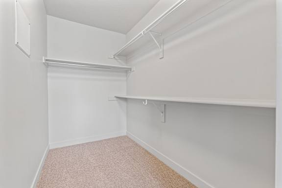A white closet with a carpeted floor and a white shelf. at Wilmington Flats Apartments, Salt Lake City