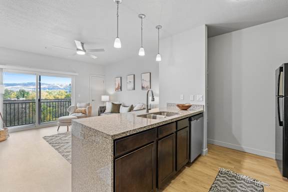A kitchen with a marble countertop and a refrigerator on the right. at Wilmington Flats Apartments, Salt Lake City
