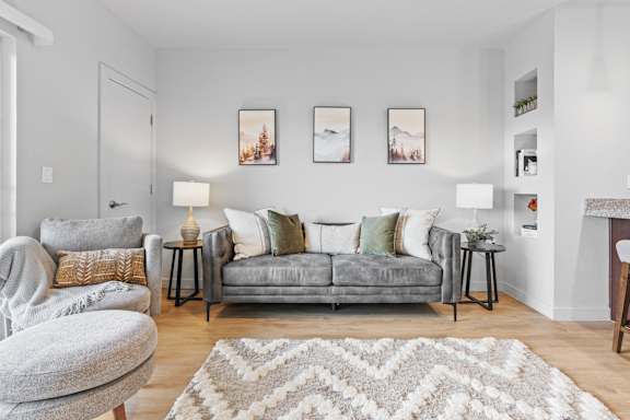 A living room with a grey couch, a grey armchair, and a rug. at Wilmington Flats Apartments, Salt Lake City