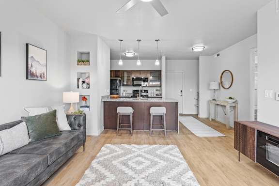 A modern living room with a grey couch and a bar area. at Wilmington Flats Apartments, Salt Lake City, 84106