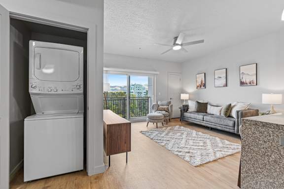 A modern living room with a television and a balcony with a view of the city. at Wilmington Flats Apartments, Salt Lake City, UT, 84106