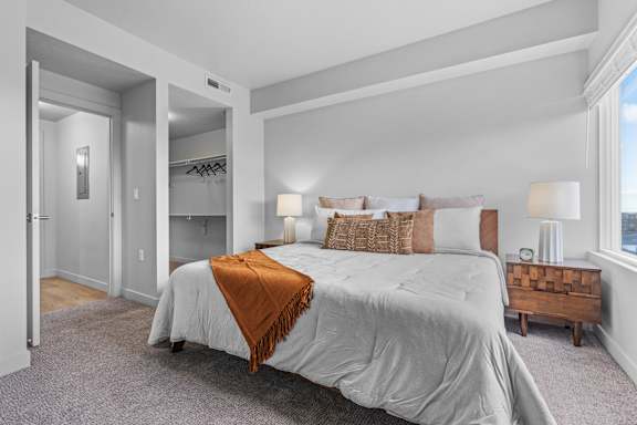 A bedroom with a large bed and a wooden nightstand. at Wilmington Flats Apartments, Utah, 84106