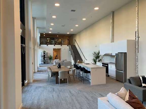 a living room with a table and chairs and a kitchen