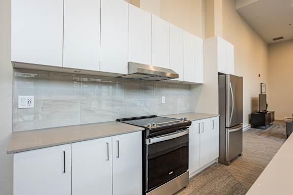A modern kitchen with white cabinets and stainless steel appliances.
