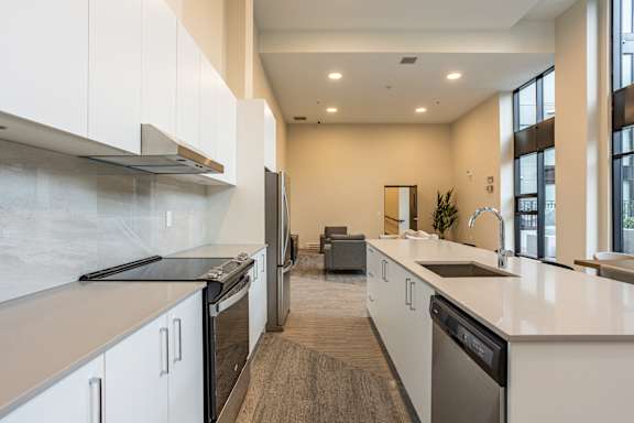 A modern kitchen with white cabinets and stainless steel appliances.