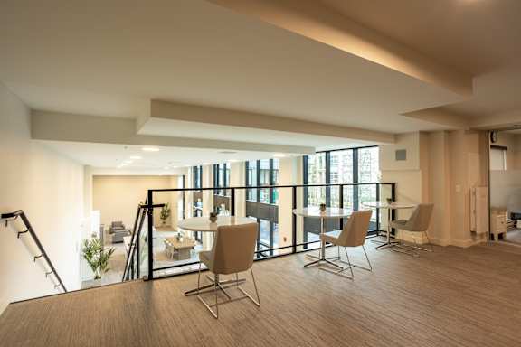 A modern living room with a dining table and chairs.
