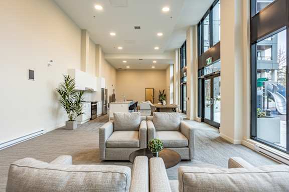 A spacious waiting area with grey couches and a plant.