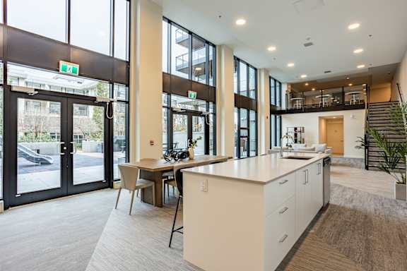 A modern kitchen with a large island and a dining table.