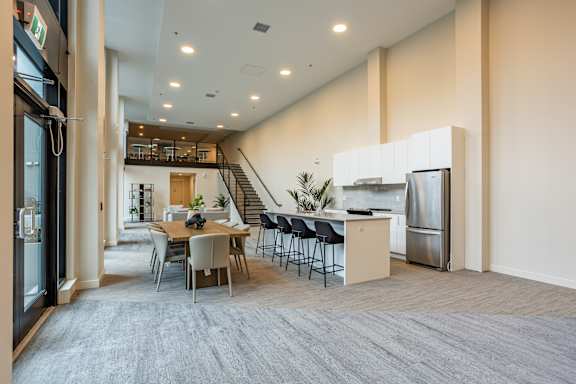 A modern kitchen with a dining table and chairs in the middle of the room.