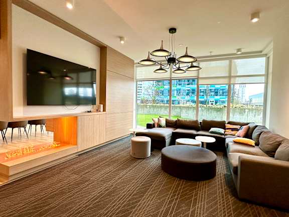 A modern living room with a flat screen TV and comfortable seating.