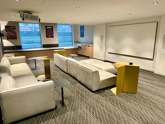 A conference room with a white screen and a long table.