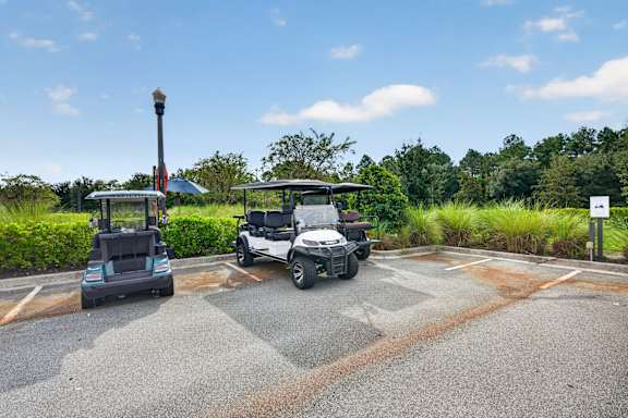 Two golf carts are parked in a parking lot.