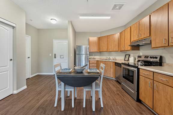 A kitchen with a table and chairs in the middle of the room.