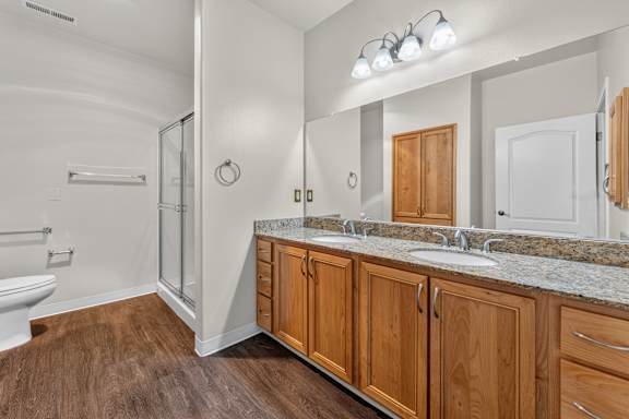A bathroom with a wooden vanity and a walk-in shower.