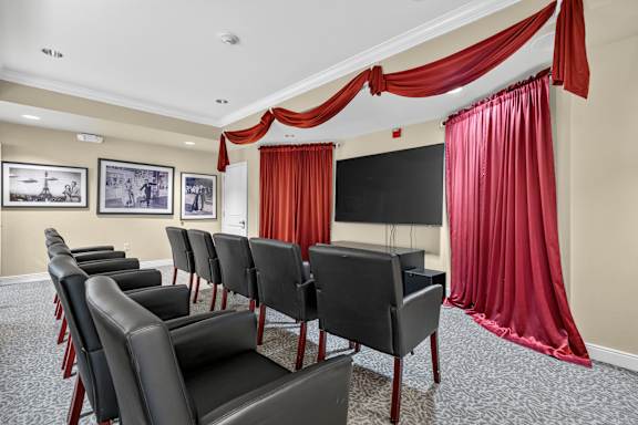 Room with a row of black chairs and red curtains at Lakeview Senior Living Apartments, Lakewood, CO