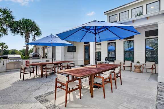 A patio with a table and chairs under a blue umbrella.