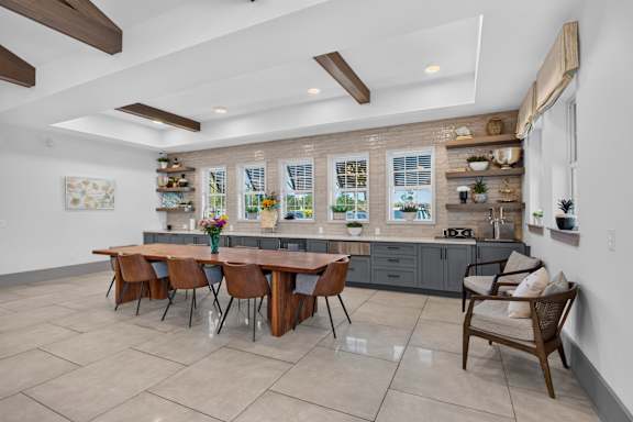 A kitchen with a table and chairs in front of a window.