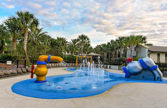 A playground with a blue water feature and a yellow slide.