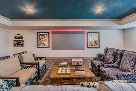A living room with a couch, a coffee table, and a neon light on the wall. at Atlas Point at Prestonwood Apartments , Carrollton, Texas