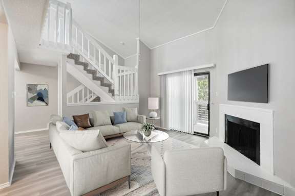 A living room with a white couch and a fireplace. at Avalon Villas Apartments , Irving, 75062