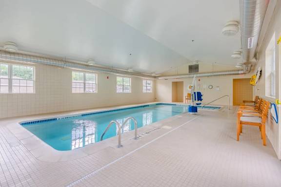 Indoor swimming pool with seating area at Glenmont Abbey Village, 55+ Apartments, Glenmont, NJ