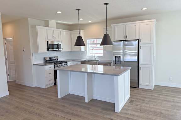 Floor Plan  A kitchen with white cabinets and a large island.