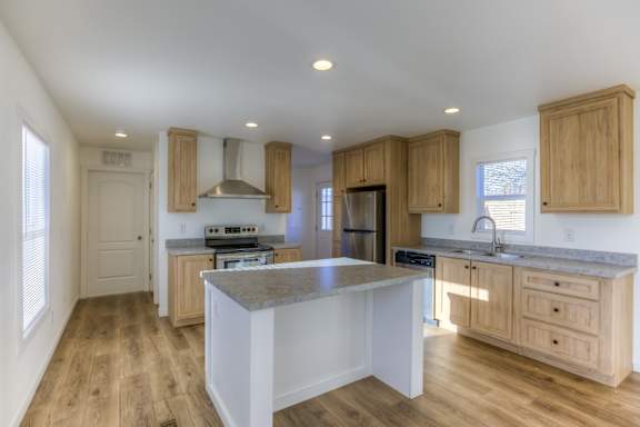 A kitchen with wooden cabinets and a marble countertop.