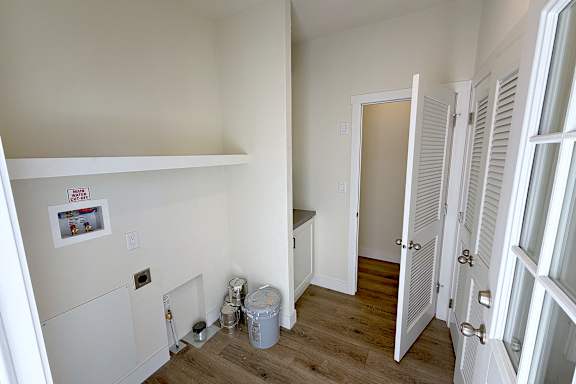 A room with a white door and a white shelf.