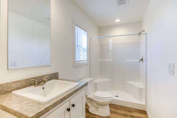A bathroom with a sink, toilet, and shower.