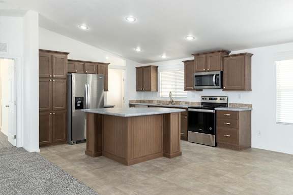 A kitchen with brown cabinets and stainless steel appliances.