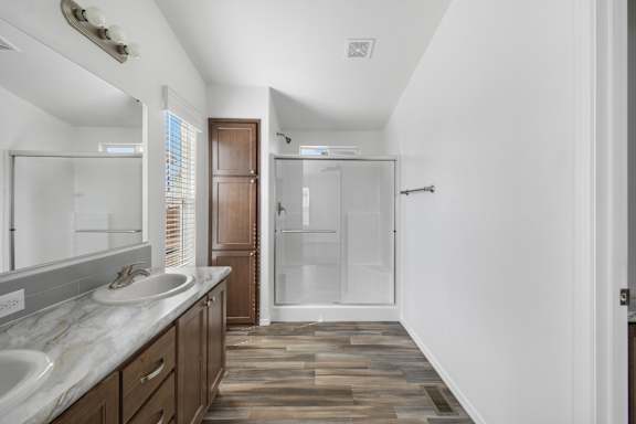 A bathroom with a white sink and a walk-in shower.