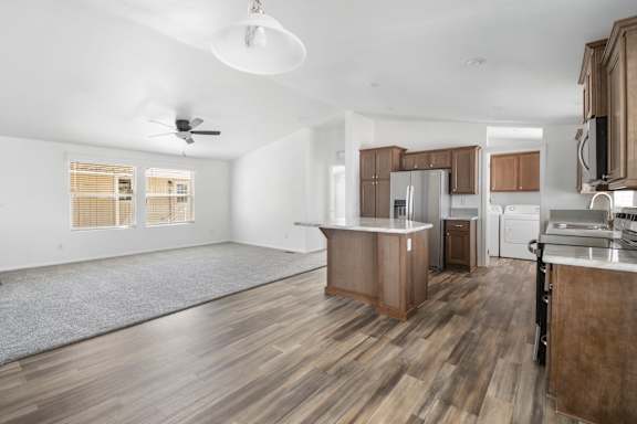 A spacious kitchen with wooden floors and modern appliances.