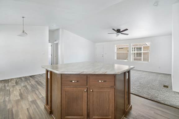 A kitchen island with wooden cabinets and a marble top.