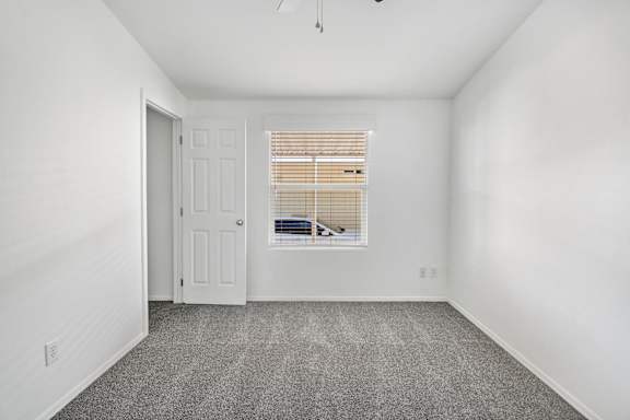 A room with a door and a window with blinds.