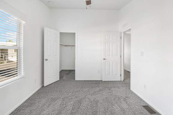 A room with white walls and a ceiling fan.